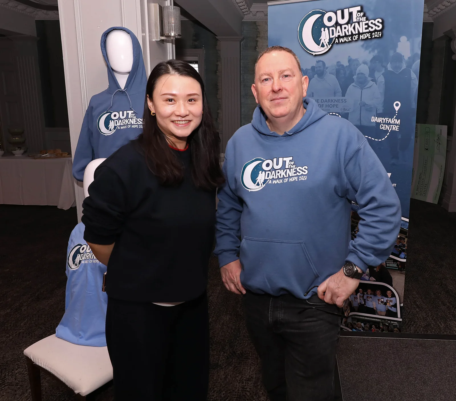 Two breakfast morning guests posing together in front of the walk banners.