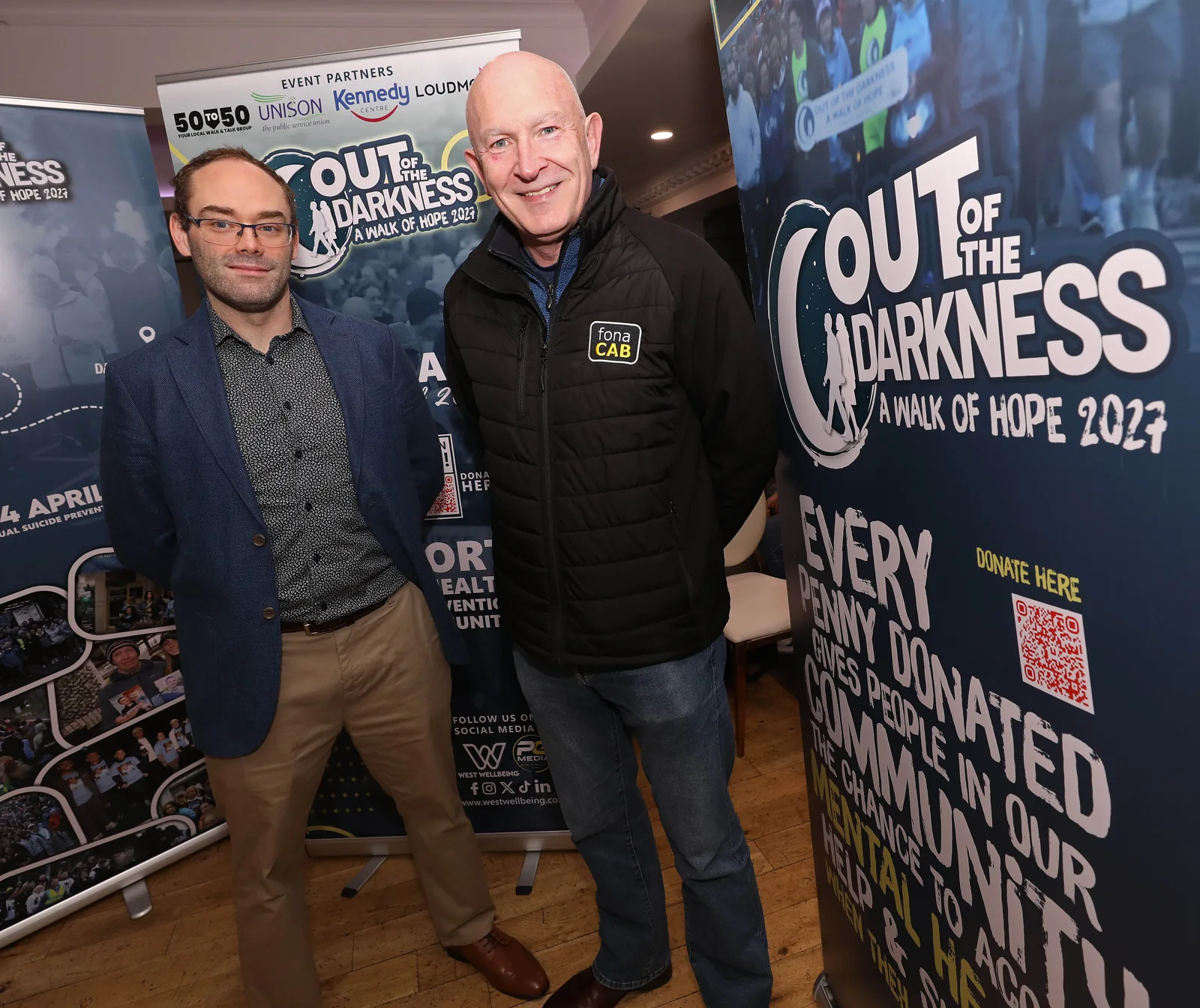 Three supporters standing beside the walk banner during the breakfast morning.